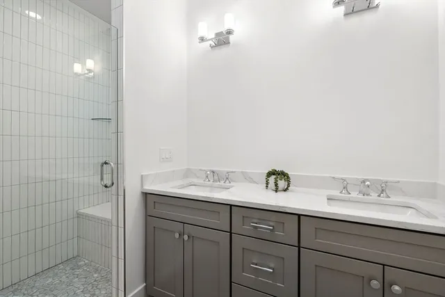 a bathroom with a granite countertop sink a mirror and shower