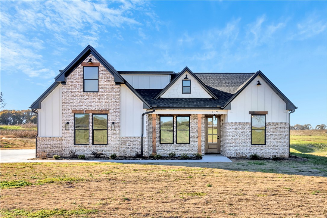 516 Lakeside Drive Anderson, SC 29621 - Photo 32 of 32 Crafted with board and batten siding, this charming brick home features elegant black-framed windows and a welcoming entryway.