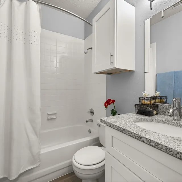 13005 Heinemann Drive, Unit 6613 Austin, TX 78727 - Photo 12 of 17 a bathroom with a granite countertop sink a toilet and bathtub