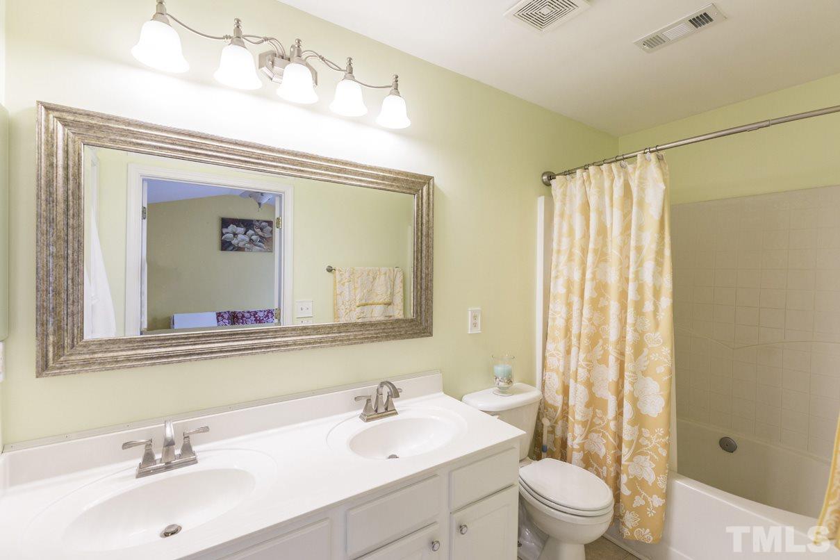 5524 Red Robin Road Raleigh, NC 27613 - Photo 14 of 24 a bathroom with a toilet a sink and a large mirror