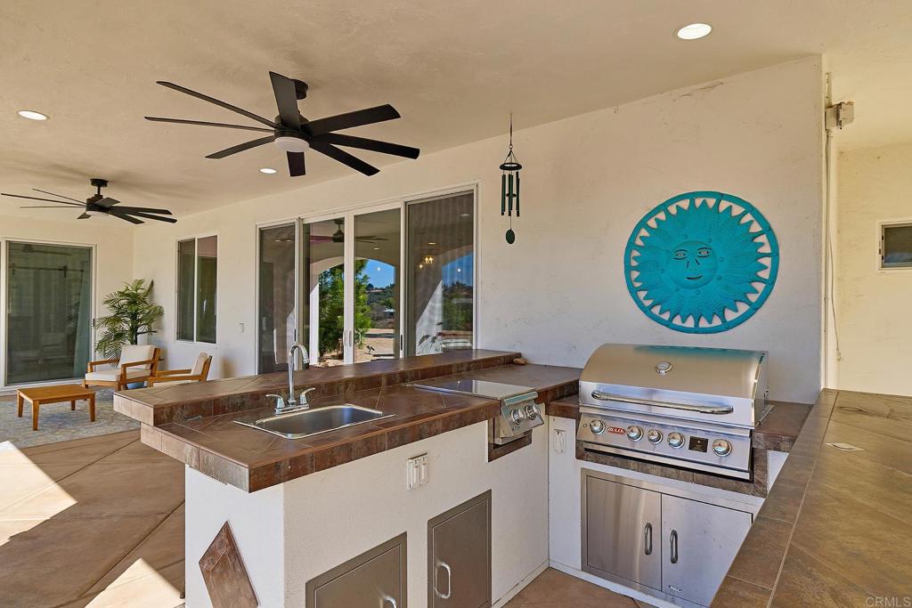 2869 Dos Lomas Place Fallbrook, CA 92028 - Photo 49 of 55 a kitchen with a stove a sink a window and a dining table