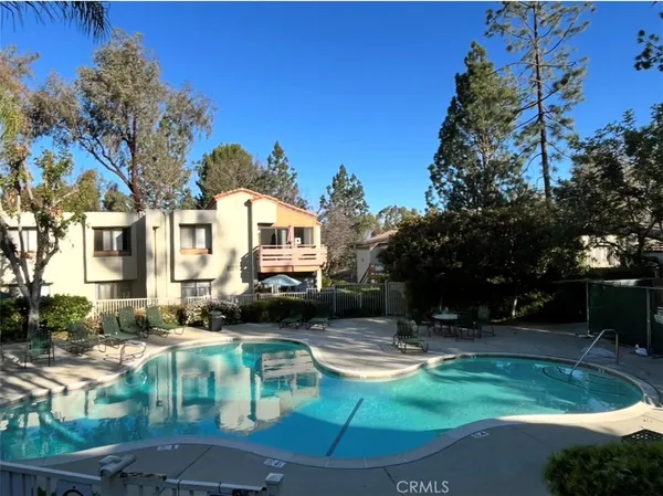 a view of a swimming pool with a yard and sitting area
