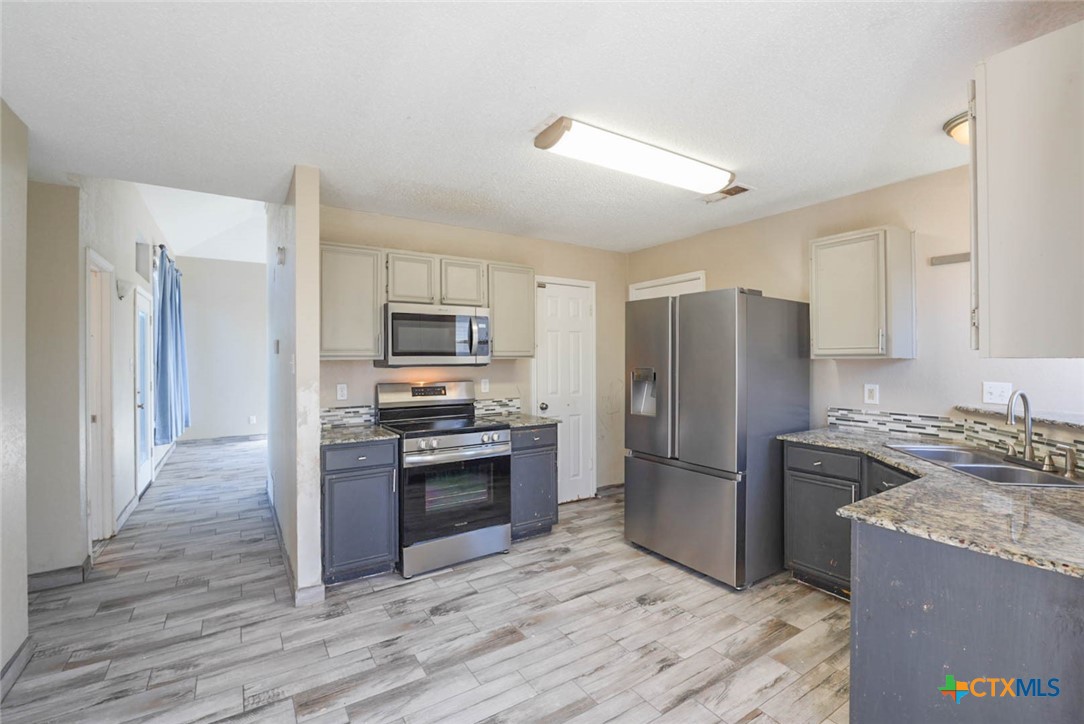 2305 Fieldstone Drive Killeen, TX 76549 - Photo 8 of 18 a kitchen with granite countertop a refrigerator stove and oven