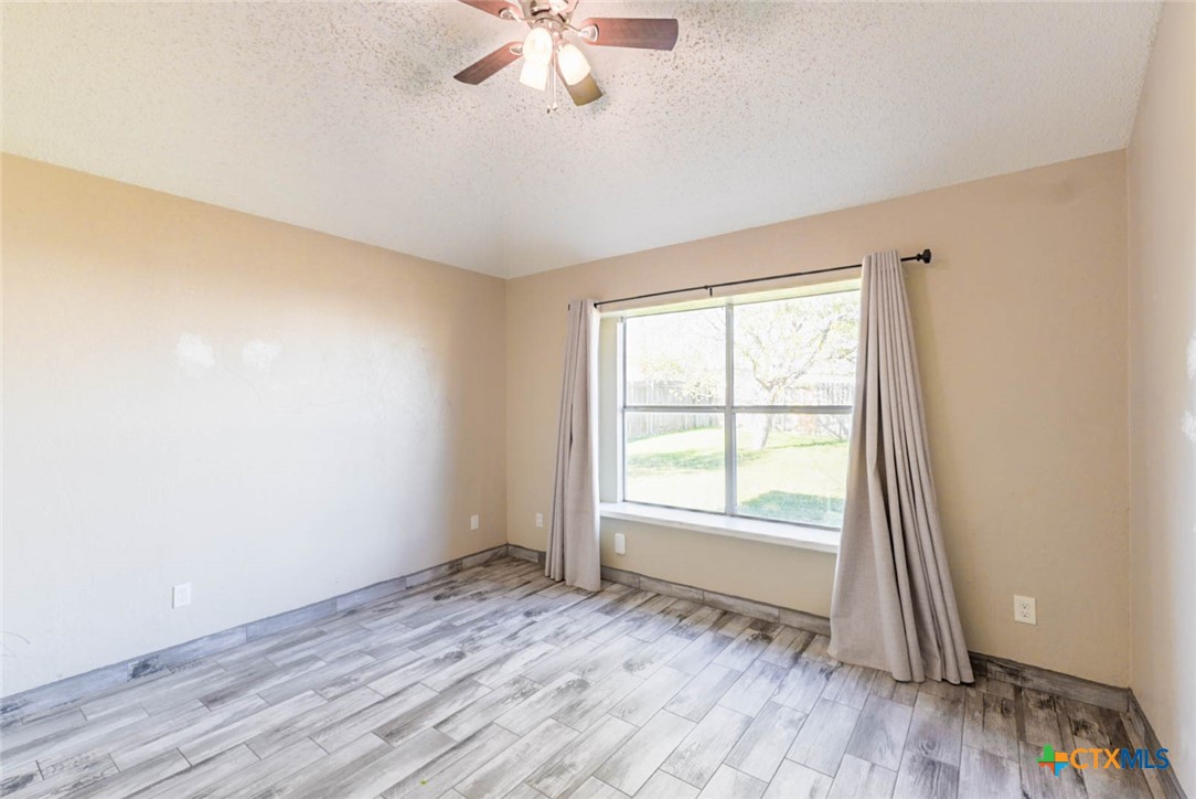 2305 Fieldstone Drive Killeen, TX 76549 - Photo 9 of 18 an empty room with wooden floor fan and windows