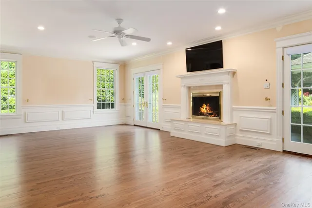 an empty room with windows fireplace and wooden floor