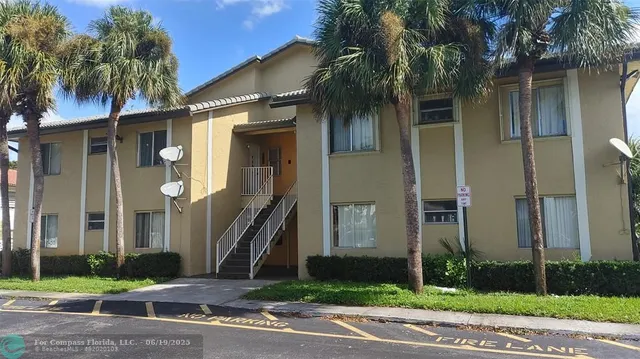 a front view of a house with a yard and palm trees