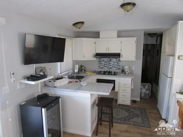 a kitchen with a sink refrigerator and cabinets