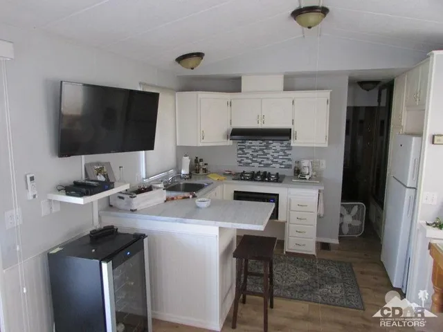 a kitchen with a sink refrigerator and cabinets