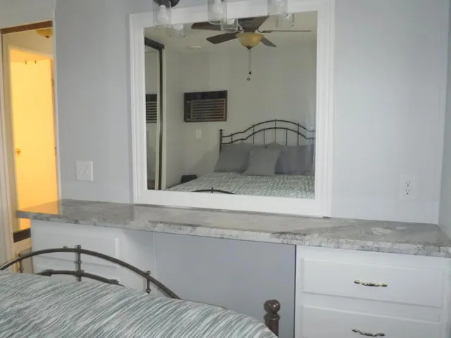 a bathroom with a granite countertop sink and a mirror
