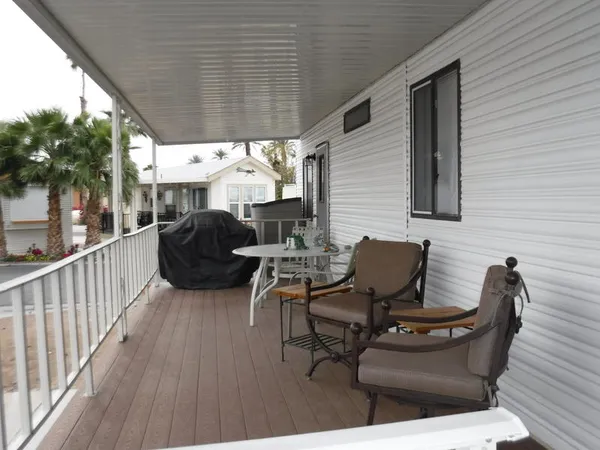 a view of a patio with table and chairs with wooden floor and fence