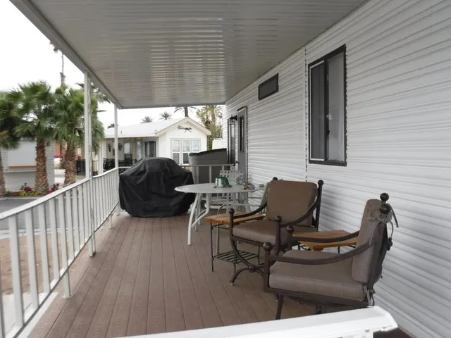 a view of a patio with table and chairs with wooden floor and fence