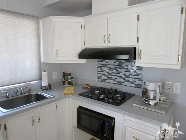 a kitchen that has a stove and a white cabinets