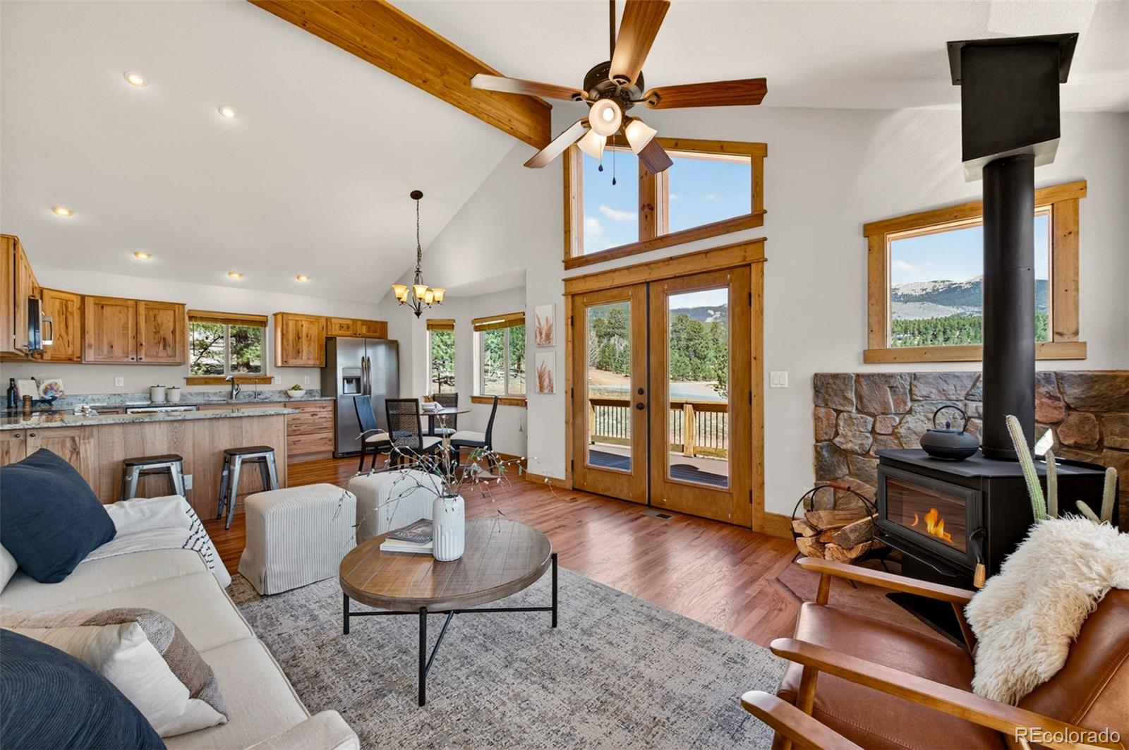 1328 Clark Road Bailey, CO 80421 - Photo 13 of 48 a living room with furniture a fireplace and a floor to ceiling window