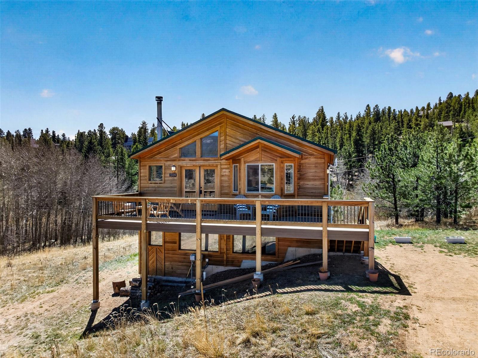 1328 Clark Road Bailey, CO 80421 - Photo 2 of 48 a wooden bench sitting in front of a house