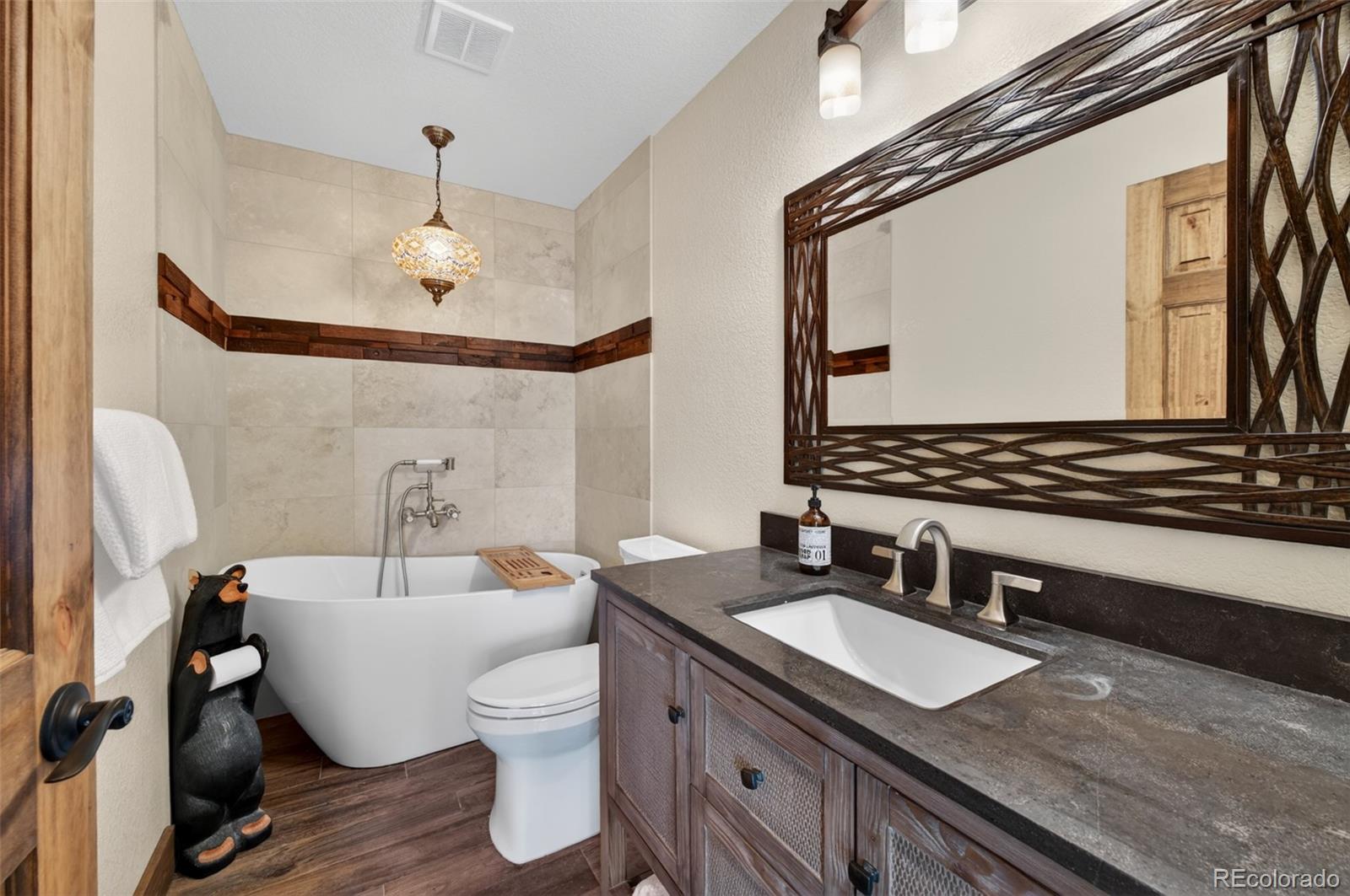 1328 Clark Road Bailey, CO 80421 - Photo 29 of 48 a bathroom with a granite countertop sink and a mirror