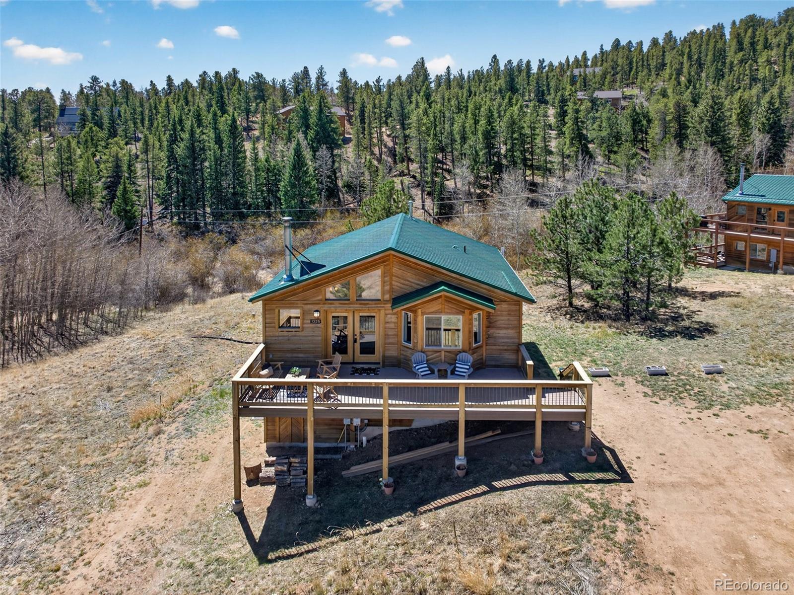 1328 Clark Road Bailey, CO 80421 - Photo 46 of 48 a view of a house with a balcony and trees with a wooden fence