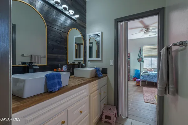 a en suite bathroom with a granite countertop sink mirror and vanity