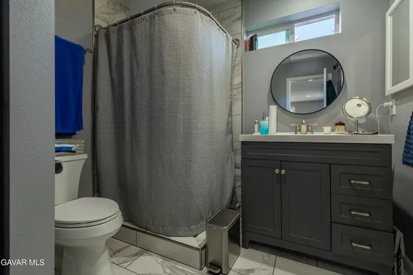 a bathroom with a toilet a sink a vanity and mirror