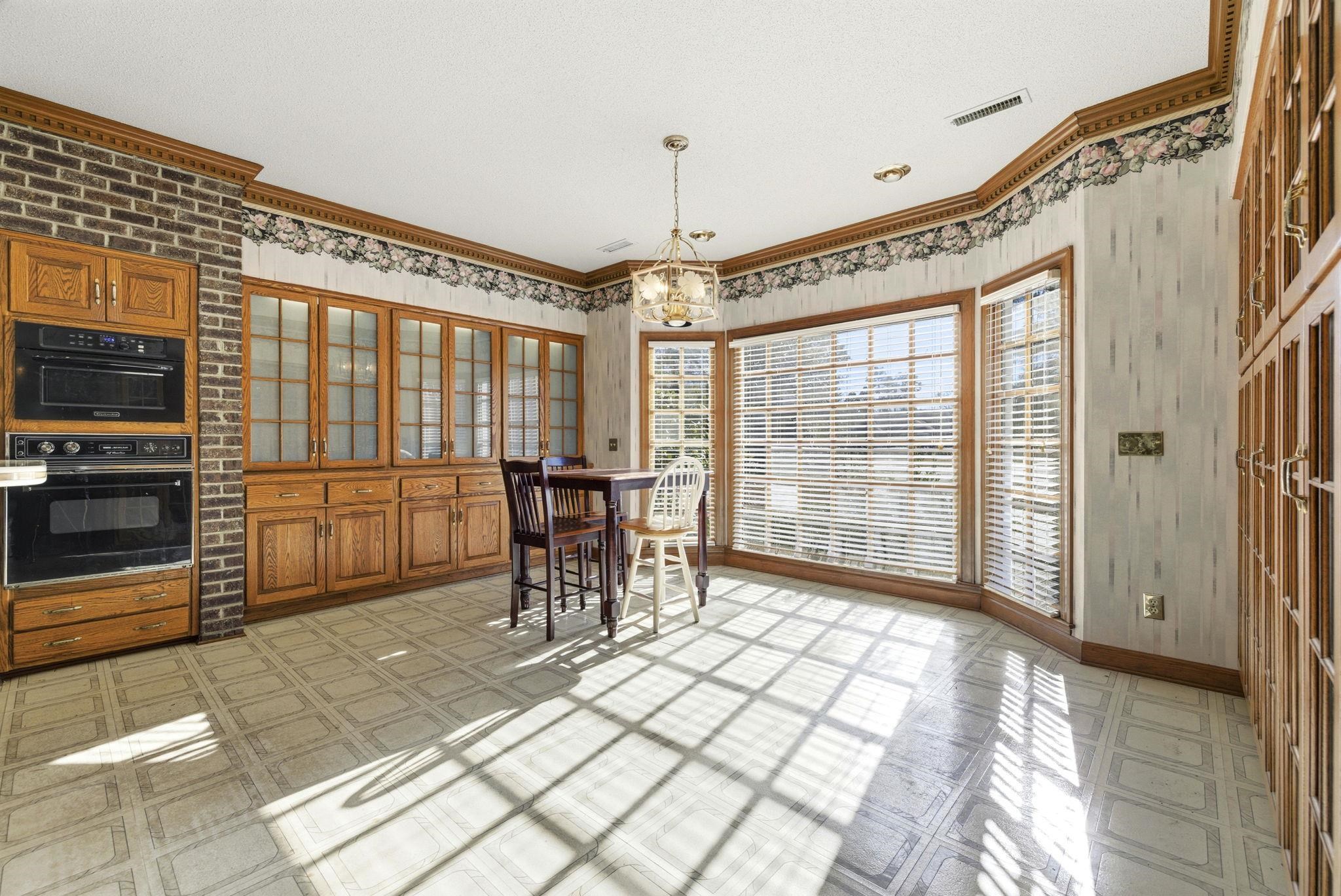 485 Carolina Drive Loris, SC 29569 - Photo 15 of 40 Kitchen featuring crown molding, brown cabinets, light flooring, pendant lighting, and a chandelier
