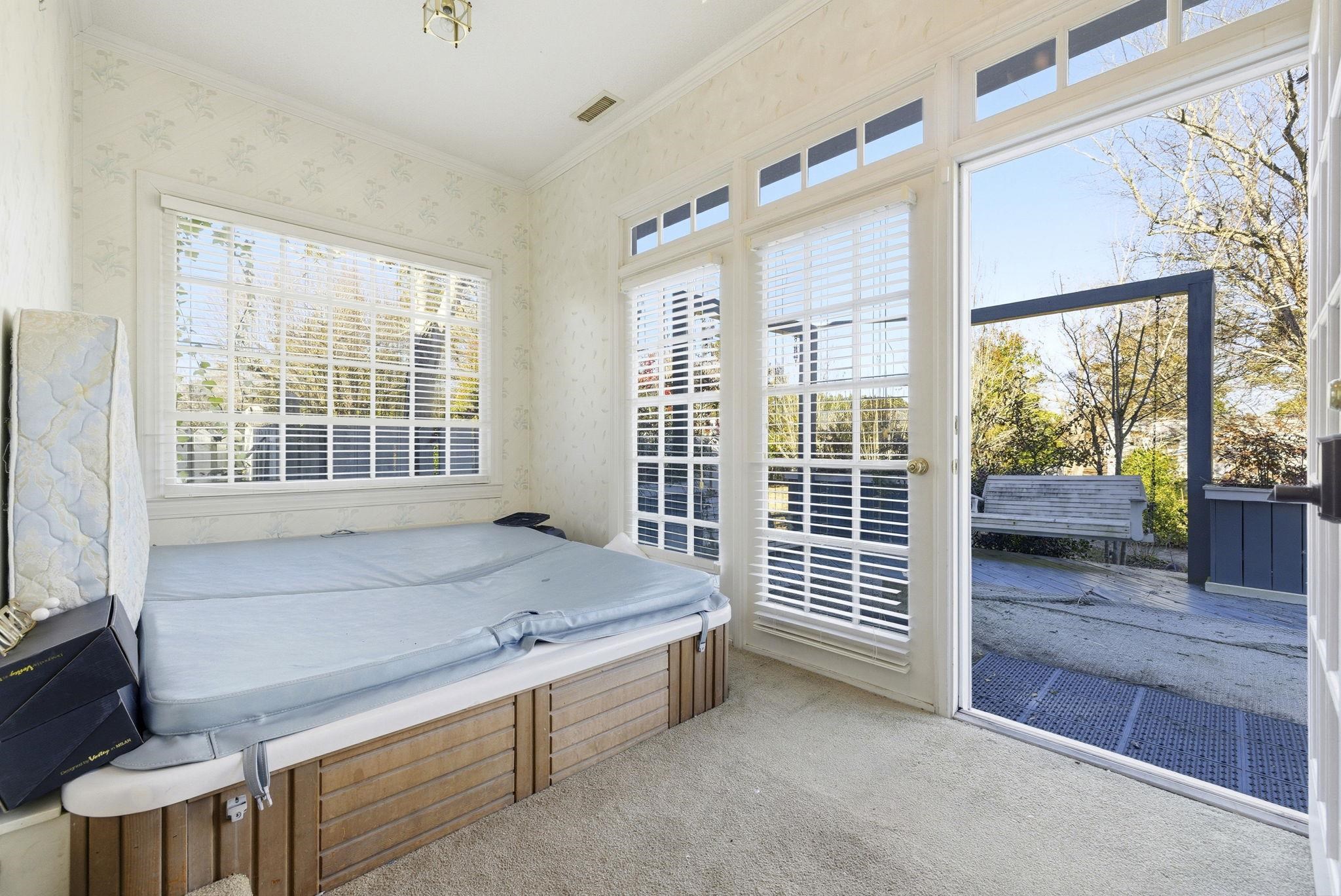 485 Carolina Drive Loris, SC 29569 - Photo 18 of 40 Bedroom featuring access to exterior, wallpapered walls, light colored carpet, and ornamental molding