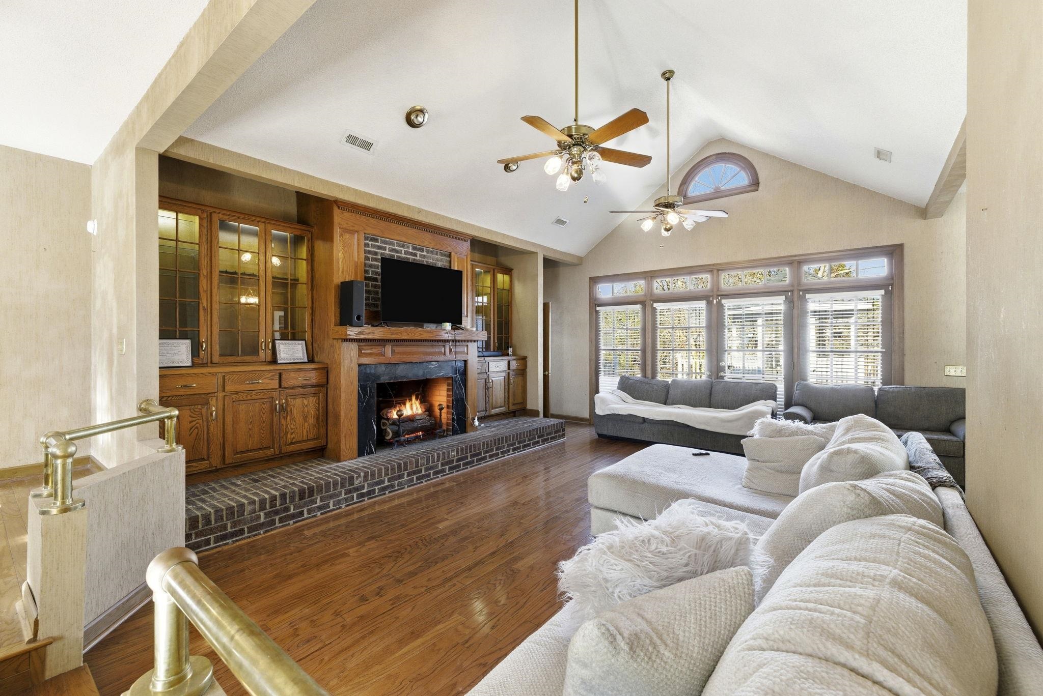485 Carolina Drive Loris, SC 29569 - Photo 3 of 40 Living area with high vaulted ceiling, wood finished floors, a brick fireplace, and a ceiling fan