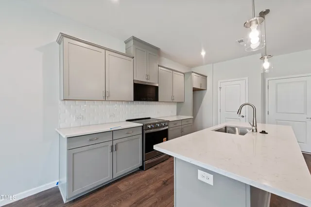 a kitchen with a sink a stove and cabinets