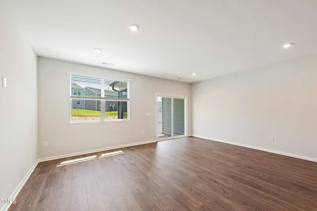 an empty room with window and wooden floor