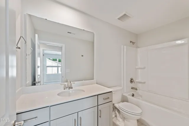 a bathroom with a sink toilet vanity granite shower and bathtub