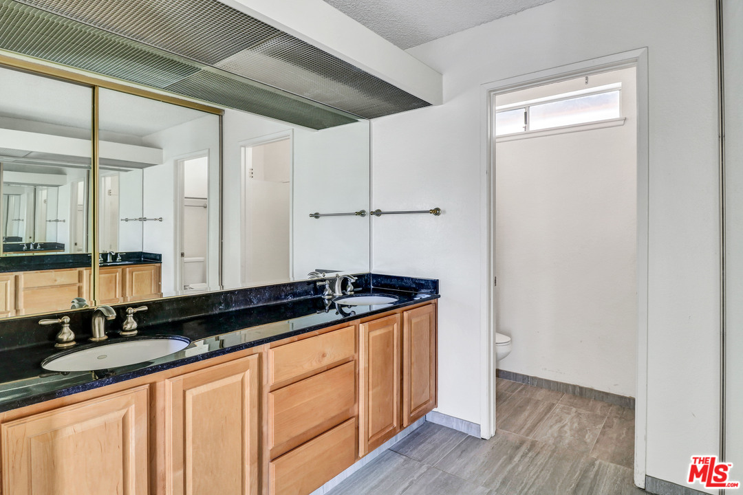 19630 Chalina Drive Walnut, CA 91789 - Photo 16 of 19 a bathroom with granite countertop a sink and a mirror