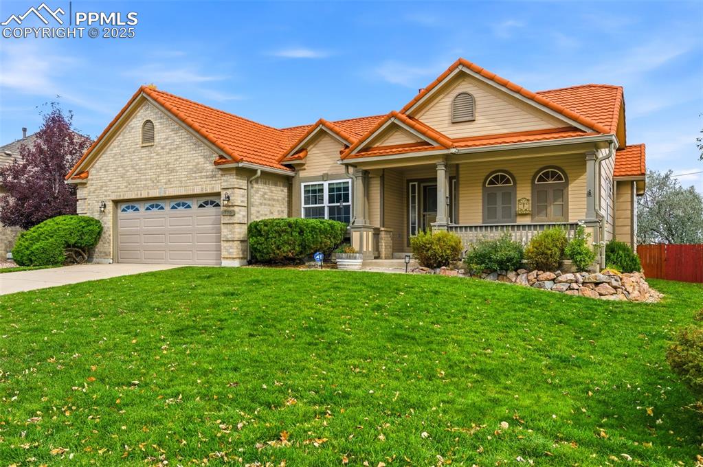 a front view of a house with a yard and potted plants