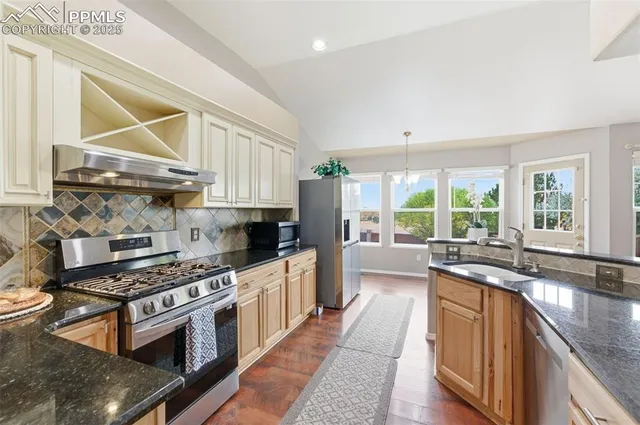 a kitchen with stainless steel appliances a stove a sink and a microwave