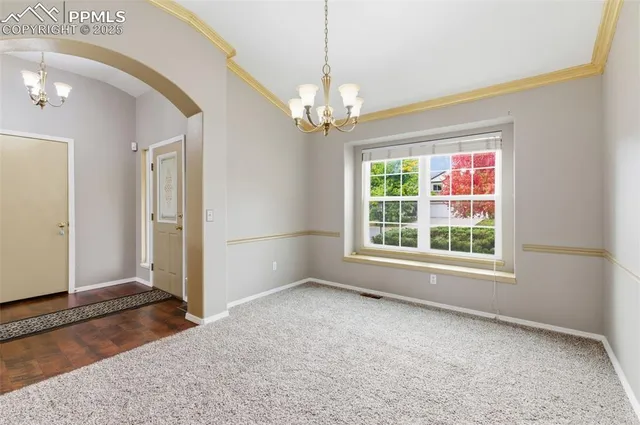 en empty room with windows and chandelier