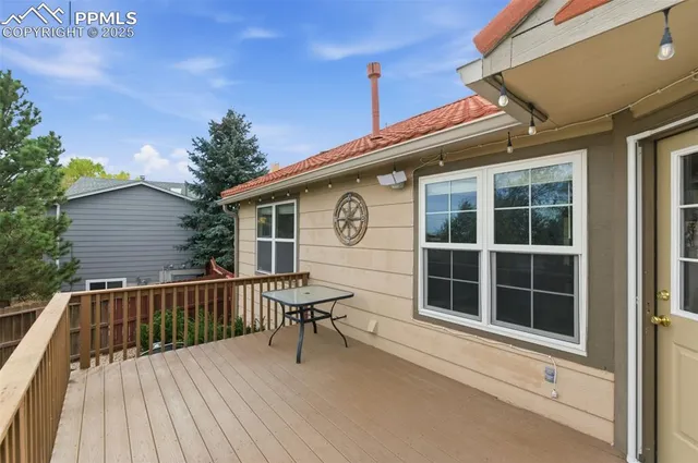 a view of a house with a large window and wooden fence