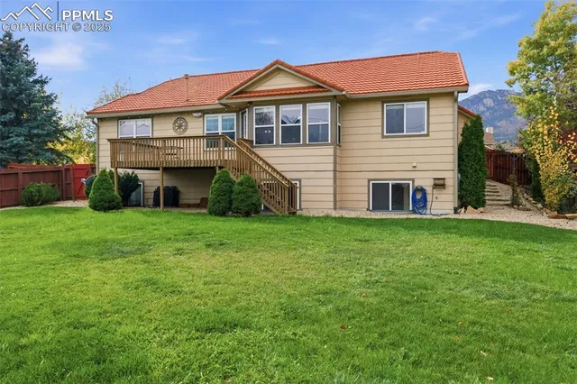 a view of a house with a yard and a large tree