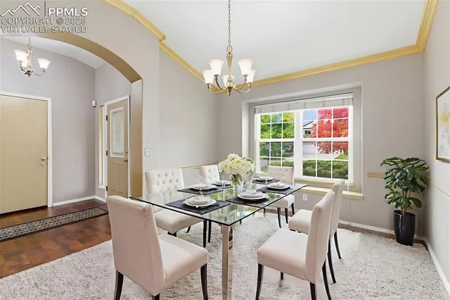 a dining room with furniture a chandelier and window