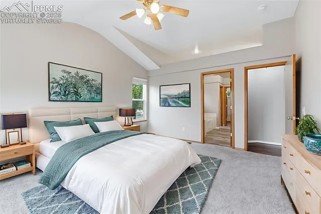 a spacious bedroom with a large bed and a chandelier