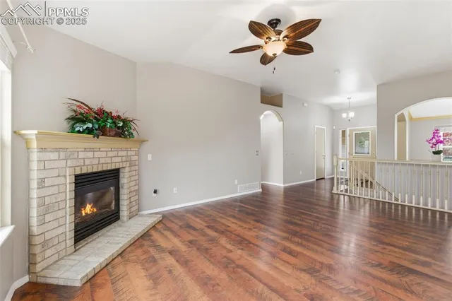 a view of empty room with wooden floor and a fireplace