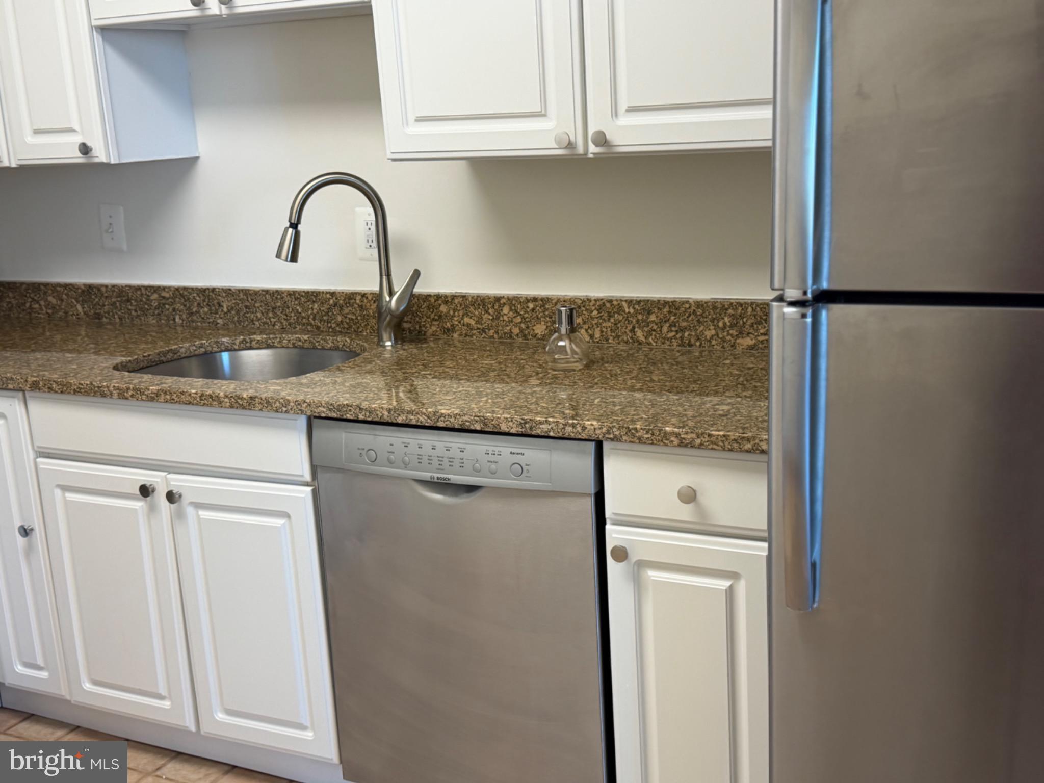 5225 Pooks Hill Road, Unit 1804N Bethesda, MD 20814 - Photo 6 of 44 a kitchen with granite countertop white cabinets and a sink