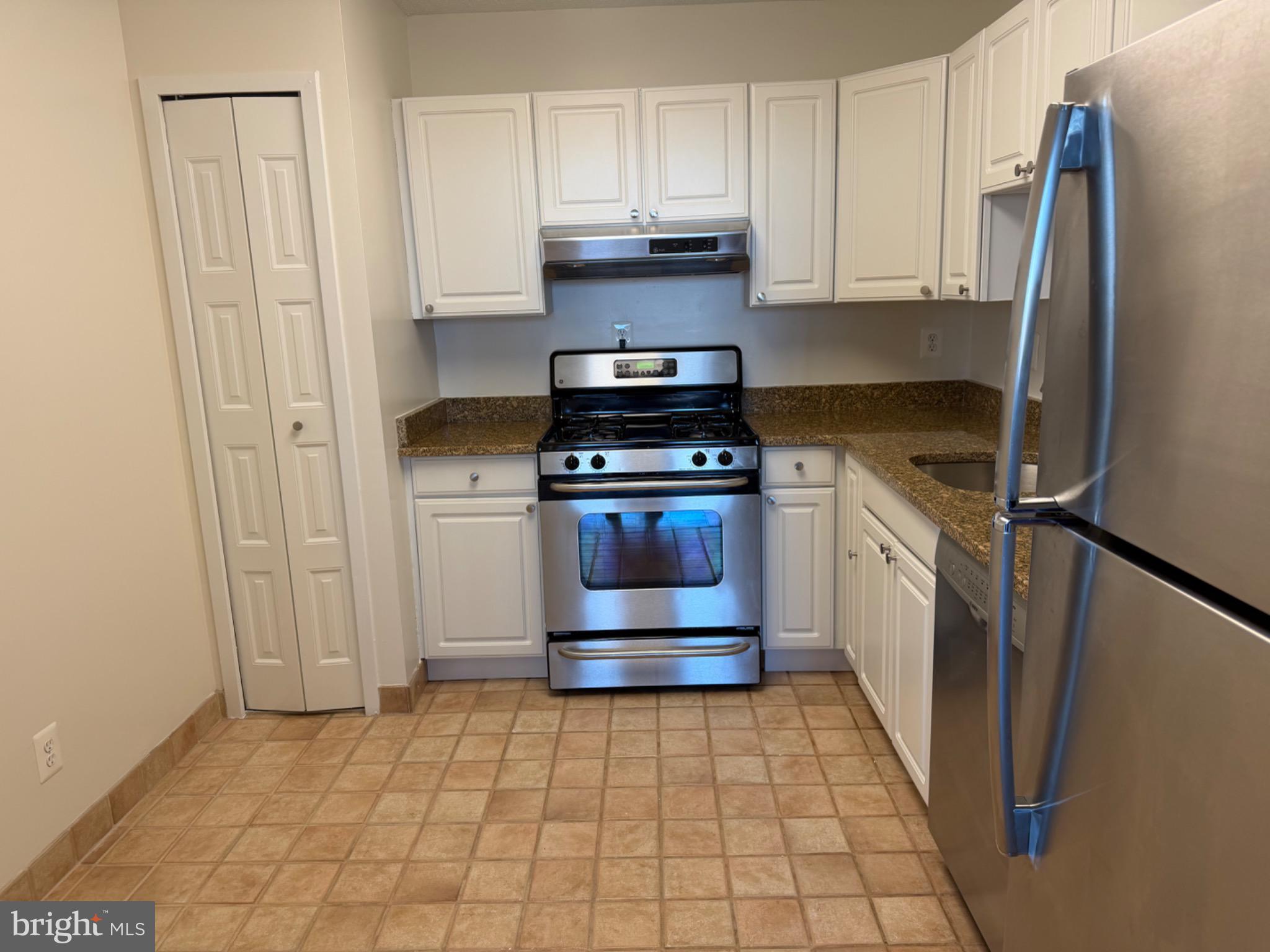 5225 Pooks Hill Road, Unit 1804N Bethesda, MD 20814 - Photo 7 of 44 a kitchen with a stove top oven and cabinets