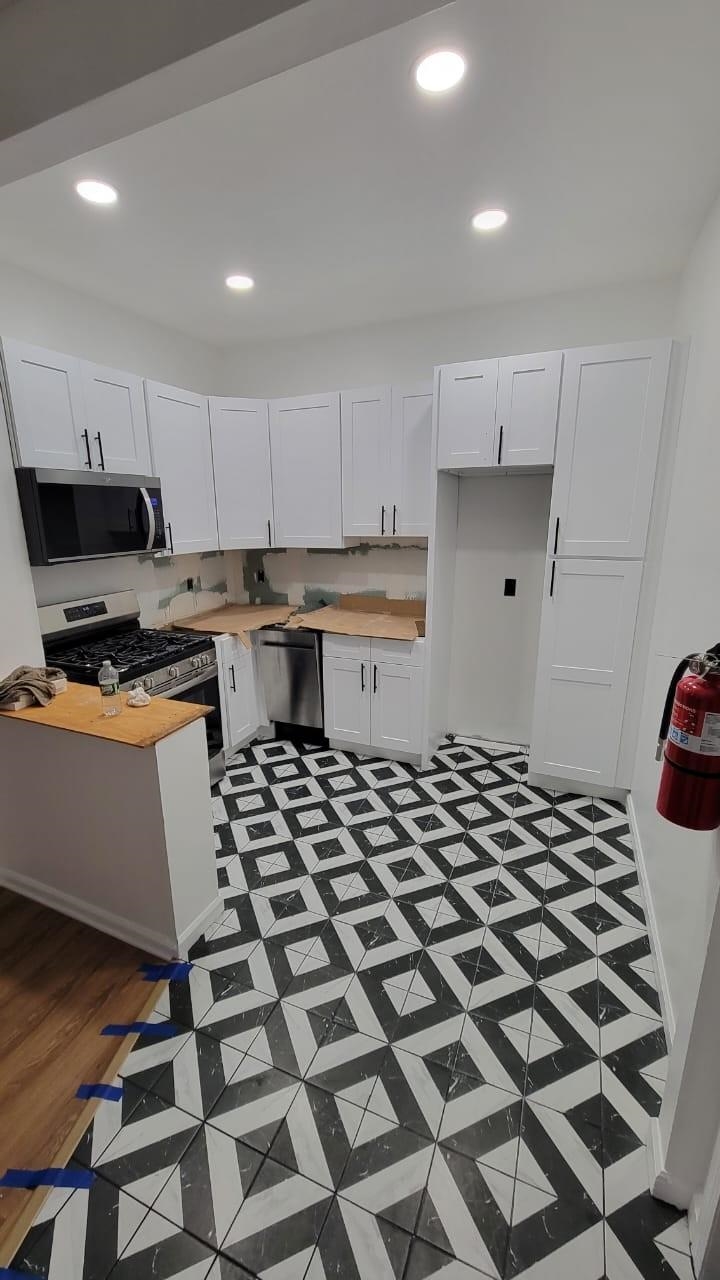 a kitchen with a checkered floor and white cabinets