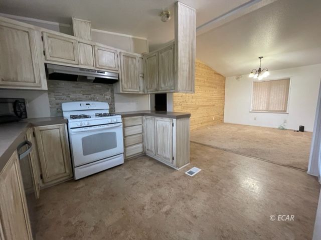 473 Spring Valley Parkway Spring Creek, NV 89815 - Photo 11 of 40 a kitchen with stainless steel appliances granite countertop a stove a sink and a refrigerator