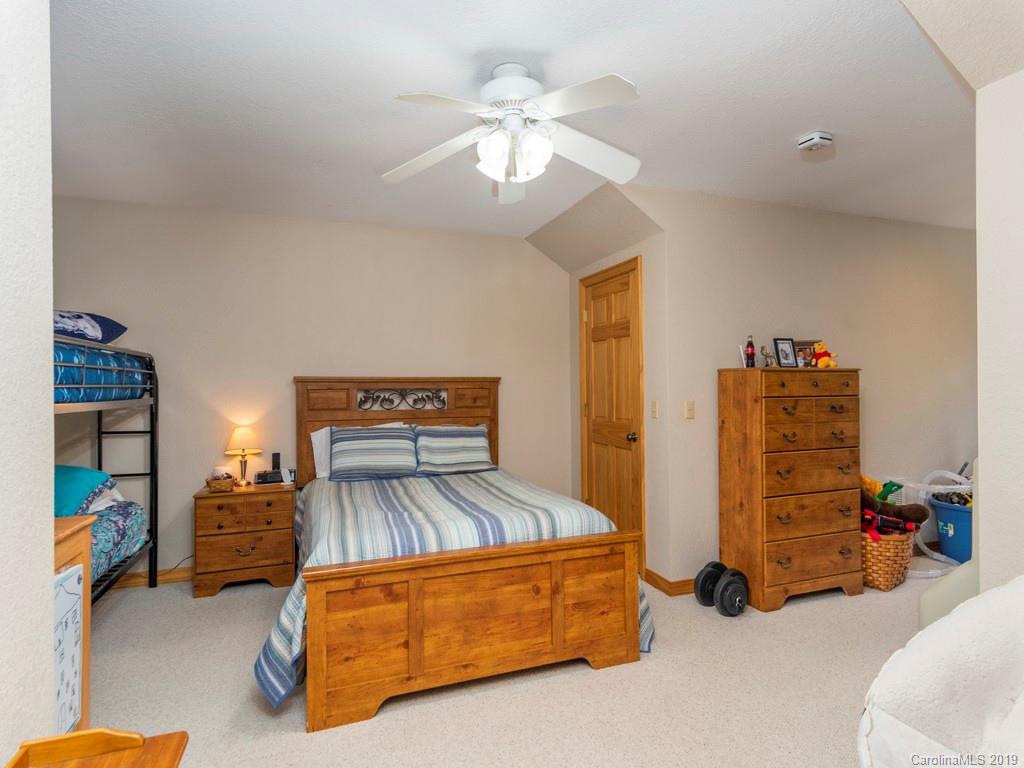 58 Thunder Ridge Road Canton, NC 28716 - Photo 12 of 26 a bedroom with furniture and a chandelier