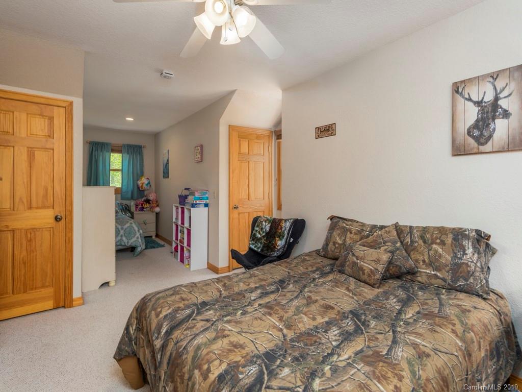 58 Thunder Ridge Road Canton, NC 28716 - Photo 15 of 26 a bedroom with a bed and a chandelier