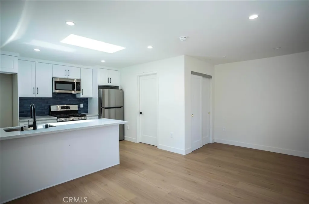 a kitchen with kitchen island a sink stainless steel appliances and cabinets