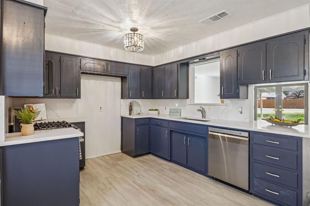 312 East Hampton Road Crowley, TX 76036 - Photo 5 of 19 Brand new stainless appliances, a 5 burner gas cooktop and stunning quartz counters and backsplash, sink, faucet and garbage disposal.