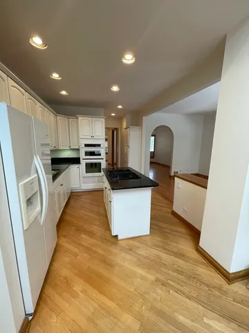 a view of kitchen with cabinets microwave and refrigerator