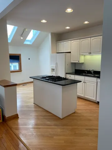 a kitchen with granite countertop a stove top oven and cabinets