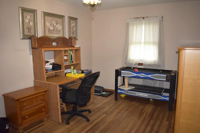 a view of a workspace with furniture and a window