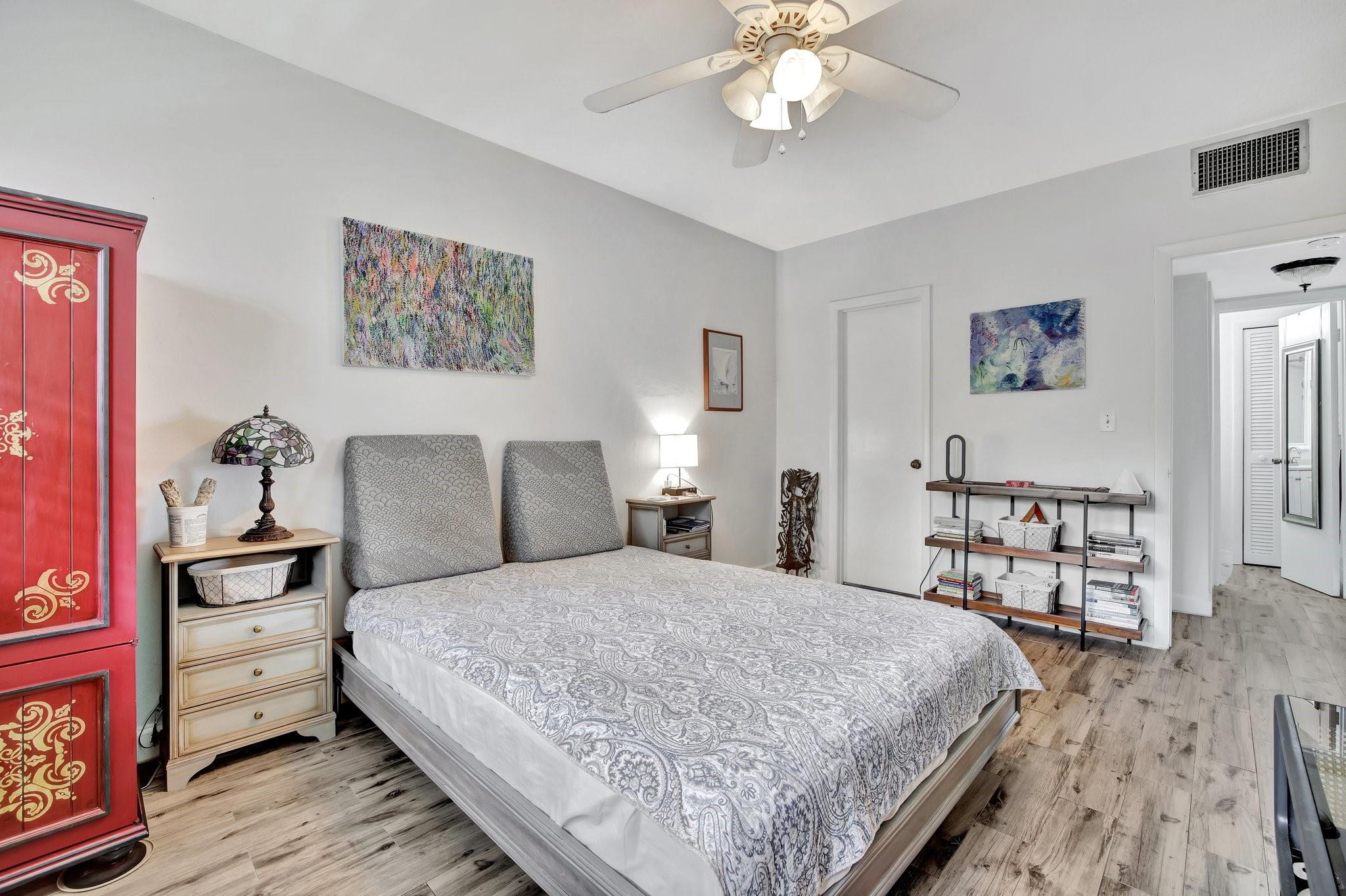 1450 North Riverside Drive, Unit 102 Pompano Beach, FL 33062 - Photo 11 of 32 a bedroom with a bed and a chandelier