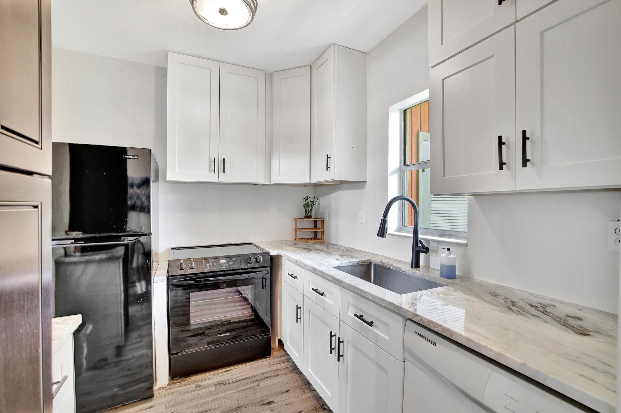 1450 North Riverside Drive, Unit 102 Pompano Beach, FL 33062 - Photo 7 of 32 a kitchen with stainless steel appliances granite countertop a sink stove and refrigerator